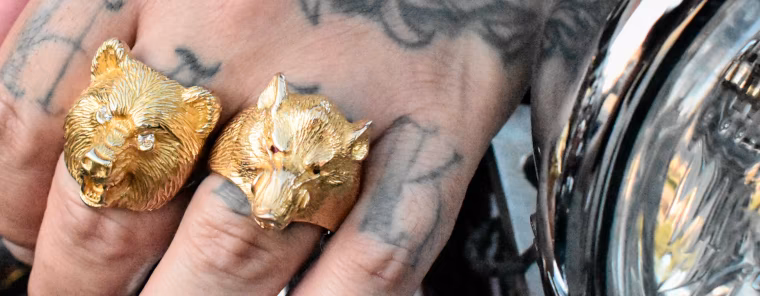 Animal jewelry, gold Bear and Boar rings over a Harley headlight
