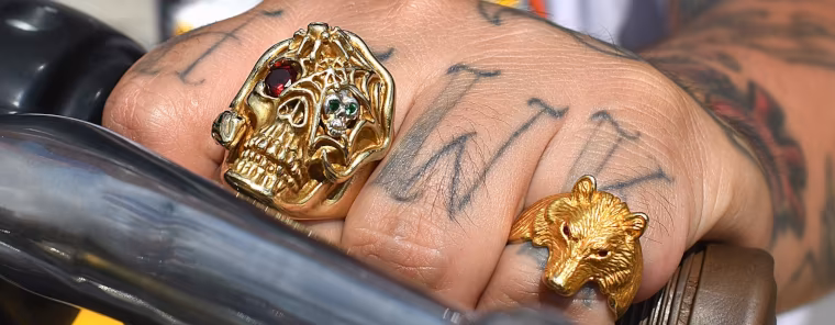Gold rings on a hand over a Harley throttle
